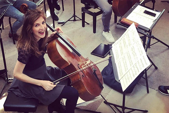 Lidy Blijdorp lachend achter de cello in orkest